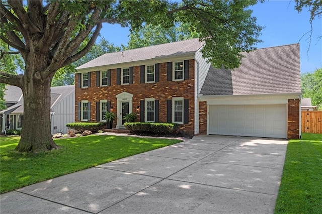 12005 W 100th Ter, Lenexa, KS 66215 - colonial inspired home featuring brick siding, concrete driveway, an attached garage, and a shingled roof