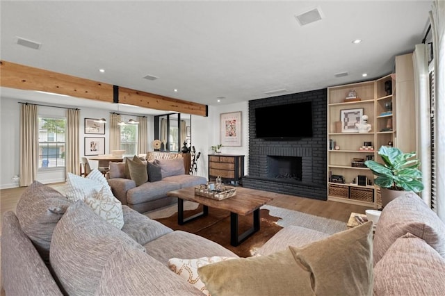 12005 W 100th Ter, Lenexa, KS 66215 - living room with wood finished floors, a brick fireplace, and recessed lighting