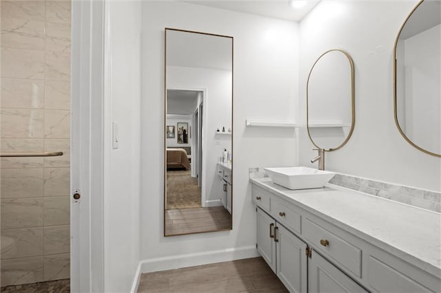 12005 W 100th Ter, Lenexa, KS 66215 - ensuite bathroom with vanity, a tile shower, and wood finished floors