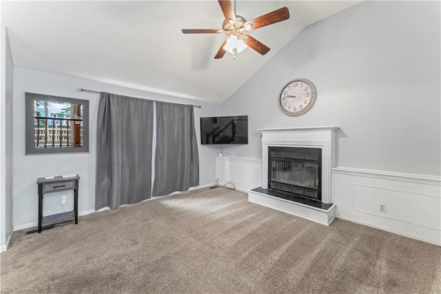 1275 NE Tudor Rd, Lees Summit, MO 64086 - unfurnished living room with carpet floors, a ceiling fan, vaulted ceiling, and a glass covered fireplace