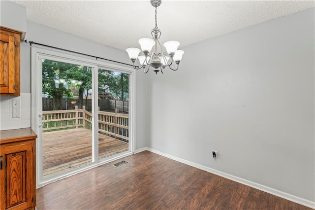 1275 NE Tudor Rd, Lees Summit, MO 64086 - unfurnished dining area with a chandelier, dark wood finished floors, and a textured ceiling