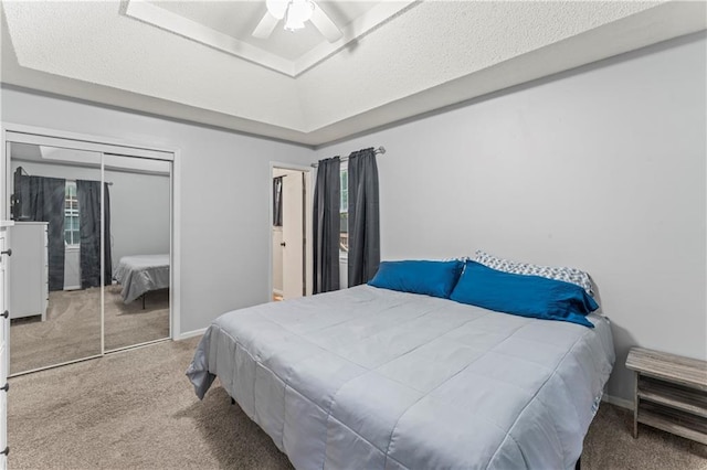 1275 NE Tudor Rd, Lees Summit, MO 64086 - bedroom with carpet floors, a tray ceiling, a closet, a ceiling fan, and a textured ceiling