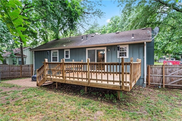 1275 NE Tudor Rd, Lees Summit, MO 64086 - rear view of house with a fenced backyard, a wooden deck, and board and batten siding