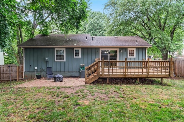 1275 NE Tudor Rd, Lees Summit, MO 64086 - back of house featuring a fenced backyard, a deck, and board and batten siding