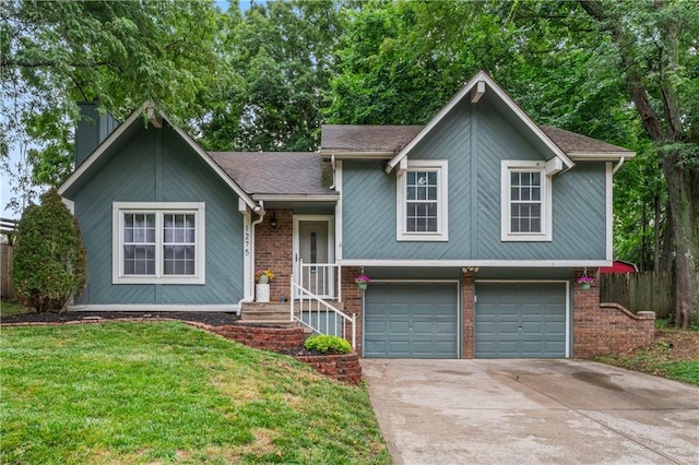 1275 NE Tudor Rd, Lees Summit, MO 64086 - split level home with an attached garage, concrete driveway, a front yard, a chimney, and brick siding