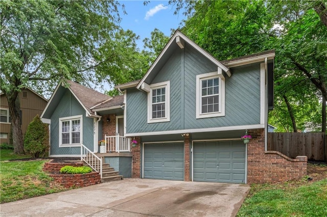 1275 NE Tudor Rd, Lees Summit, MO 64086 - split level home with a garage, driveway, and brick siding
