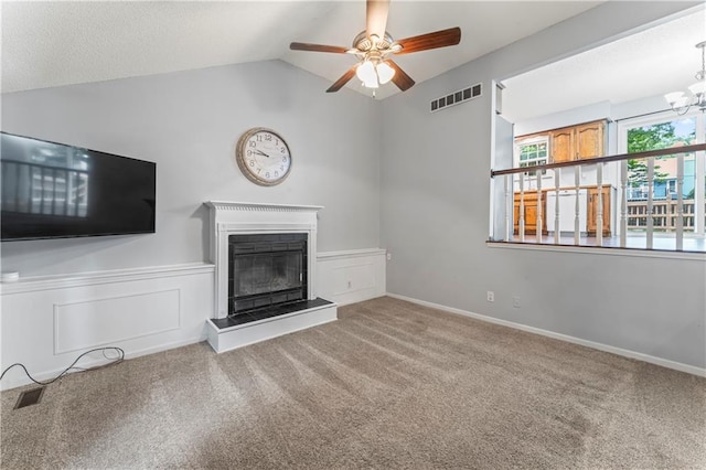 1275 NE Tudor Rd, Lees Summit, MO 64086 - unfurnished living room with carpet flooring, ceiling fan, lofted ceiling, a glass covered fireplace, and a wainscoted wall