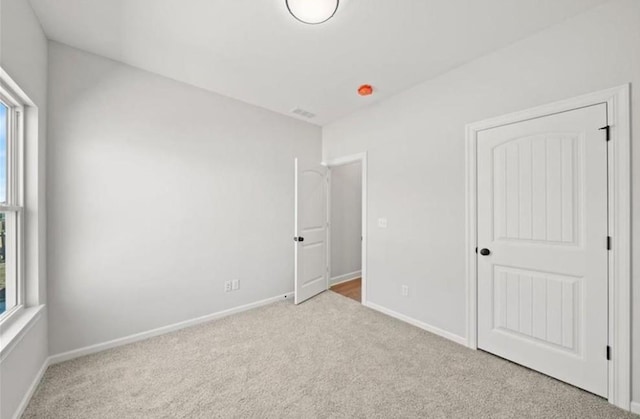 210 S Devin St, Lone Jack, MO 64070 - unfurnished bedroom with multiple windows and carpet