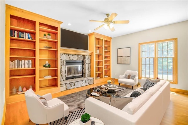 245 SW 400th Rd, Warrensburg, MO 64093 - living area featuring wood finished floors, a stone fireplace, ceiling fan, built in features, and recessed lighting