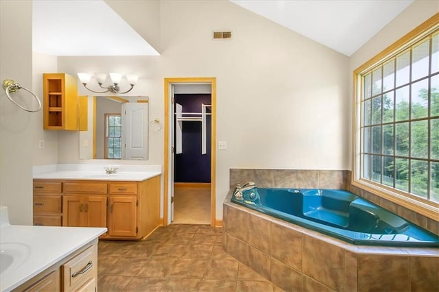 245 SW 400th Rd, Warrensburg, MO 64093 - full bath with vaulted ceiling, two vanities, a chandelier, a garden tub, and tile patterned flooring