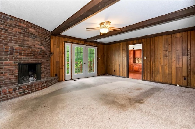 12417 Newton Ct, Grandview, MO 64030 - unfurnished living room featuring beamed ceiling, wooden walls, carpet, a fireplace, and a ceiling fan