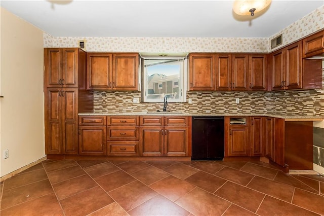 12417 Newton Ct, Grandview, MO 64030 - kitchen with brown cabinets, backsplash, light stone counters, and dark tile patterned floors