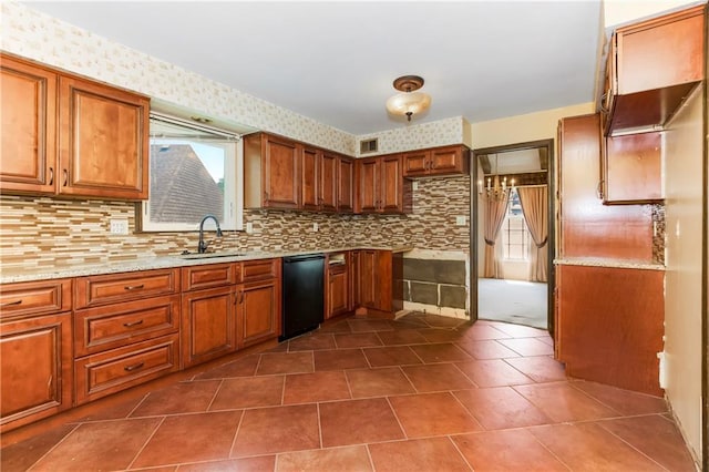 12417 Newton Ct, Grandview, MO 64030 - kitchen featuring black dishwasher, brown cabinets, backsplash, dark tile patterned floors, and light stone counters