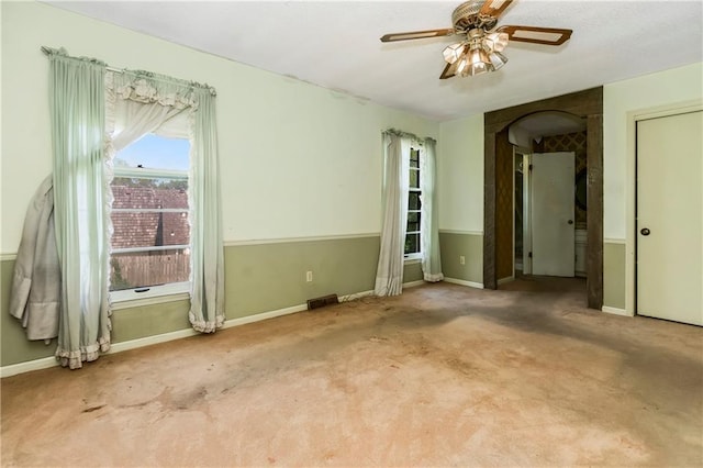 12417 Newton Ct, Grandview, MO 64030 - carpeted spare room featuring ceiling fan and arched walkways