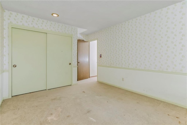 12417 Newton Ct, Grandview, MO 64030 - unfurnished bedroom featuring wallpapered walls, carpet, and a closet