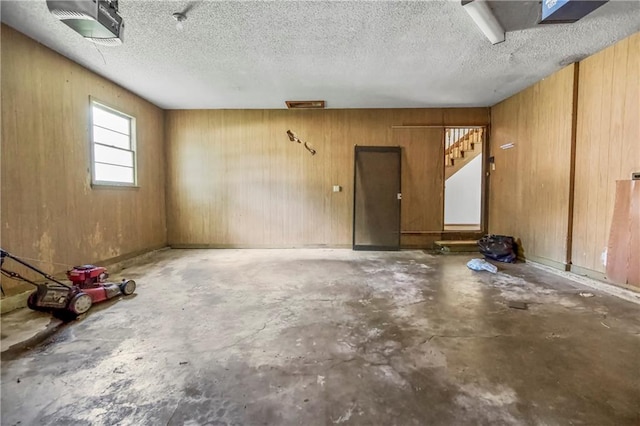 12417 Newton Ct, Grandview, MO 64030 - garage featuring a garage door opener and wooden walls