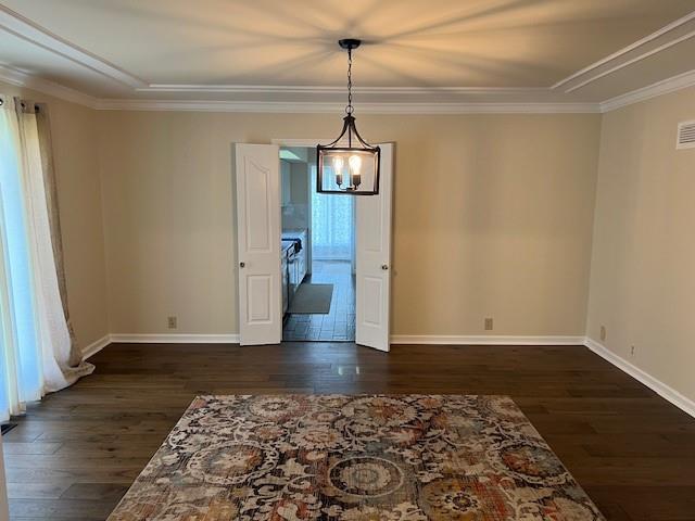 1901 NE River Ridge Rd, Saint Joseph, MO 64507 - spare room with crown molding, dark wood-style flooring, and a chandelier