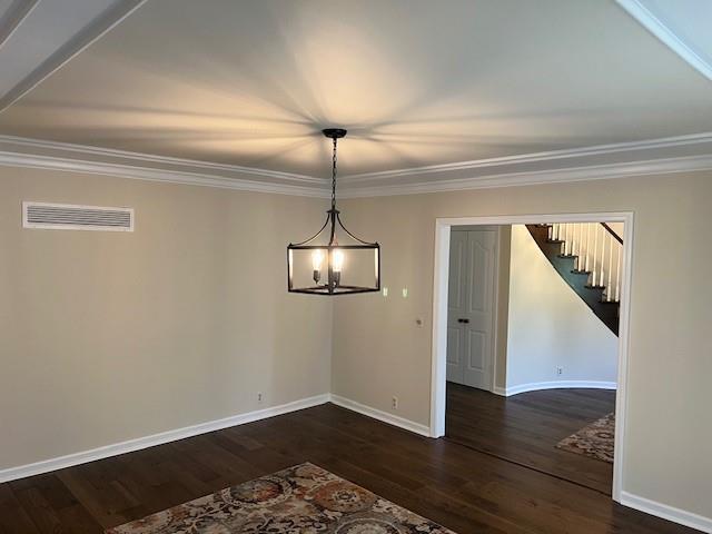 1901 NE River Ridge Rd, Saint Joseph, MO 64507 - unfurnished dining area featuring ornamental molding, dark wood finished floors, stairway, and a chandelier