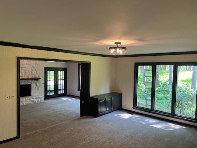 1901 NE River Ridge Rd, Saint Joseph, MO 64507 - carpeted spare room with ornamental molding, french doors, and a stone fireplace