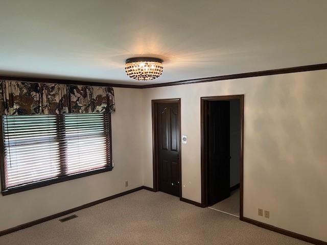 1901 NE River Ridge Rd, Saint Joseph, MO 64507 - empty room with light carpet and crown molding