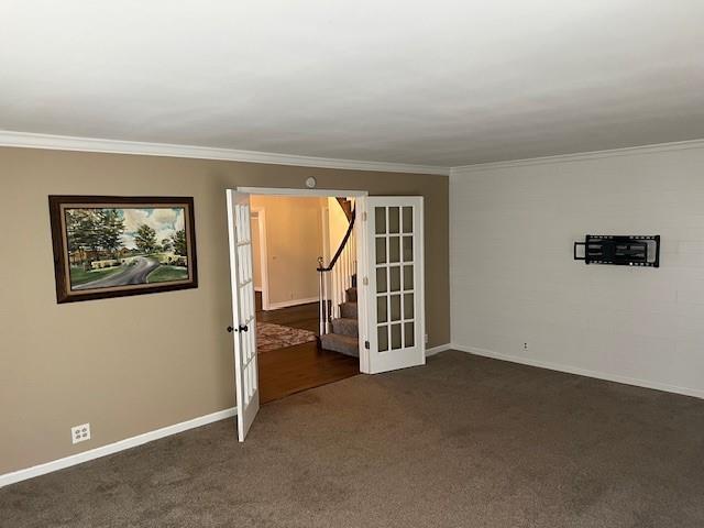1901 NE River Ridge Rd, Saint Joseph, MO 64507 - empty room featuring dark colored carpet, ornamental molding, french doors, and stairway
