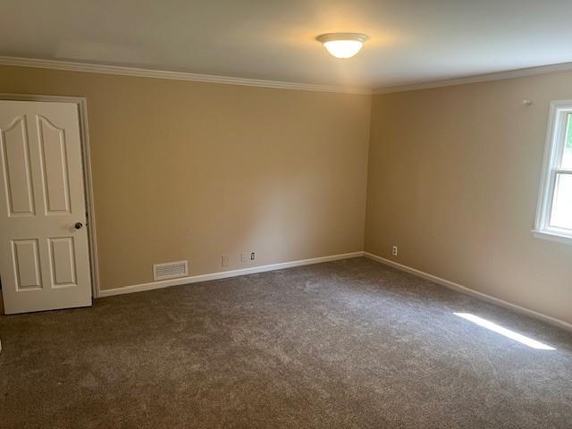 1901 NE River Ridge Rd, Saint Joseph, MO 64507 - empty room featuring dark colored carpet and crown molding