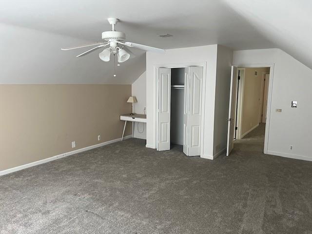 1901 NE River Ridge Rd, Saint Joseph, MO 64507 - unfurnished bedroom with lofted ceiling, dark carpet, a closet, and ceiling fan