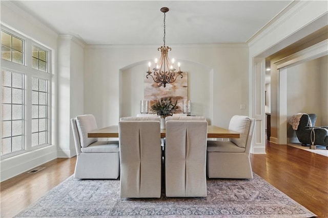 10654 W 168th Ct, Overland Park, KS 66221 - dining area featuring a chandelier, ornamental molding, wood finished floors, and arched walkways