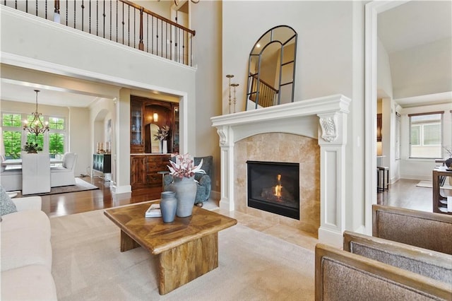 10654 W 168th Ct, Overland Park, KS 66221 - living area featuring a chandelier, a towering ceiling, stairs, and a tile fireplace