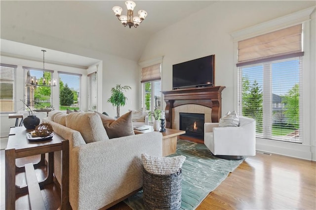 10654 W 168th Ct, Overland Park, KS 66221 - living room featuring a chandelier, wood finished floors, a fireplace, and lofted ceiling