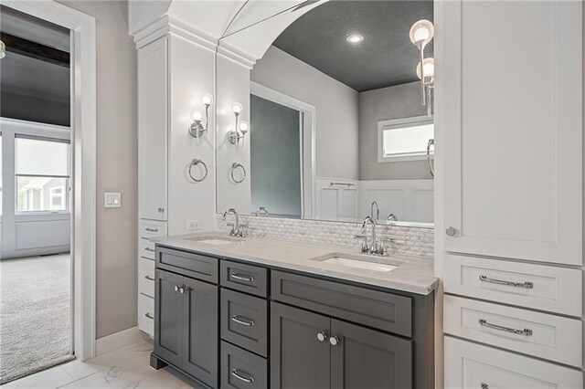 17117 Bluejacket St, Overland Park, KS 66221 - bathroom with double vanity, tasteful backsplash, and marble finish flooring