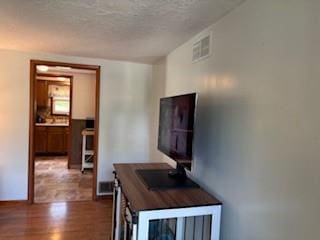 114 S Appleton St, Sugar Creek, MO 64054 - hall featuring wood finished floors and a textured ceiling