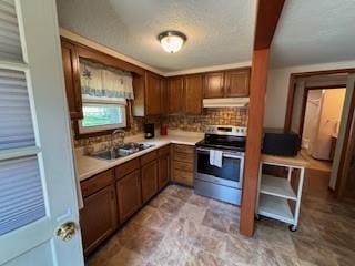 114 S Appleton St, Sugar Creek, MO 64054 - kitchen with stainless steel electric range, under cabinet range hood, tasteful backsplash, and light countertops