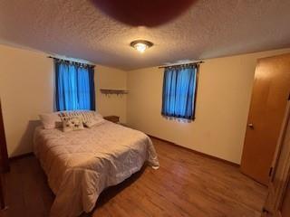 114 S Appleton St, Sugar Creek, MO 64054 - bedroom featuring a textured ceiling and wood finished floors