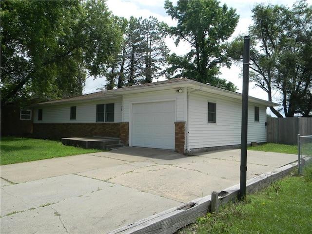 811 E Garfield St, Iola, KS 66749 - ranch-style house featuring an attached garage, driveway, and brick siding