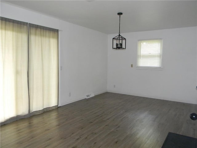 811 E Garfield St, Iola, KS 66749 - spare room featuring dark wood-type flooring and baseboards
