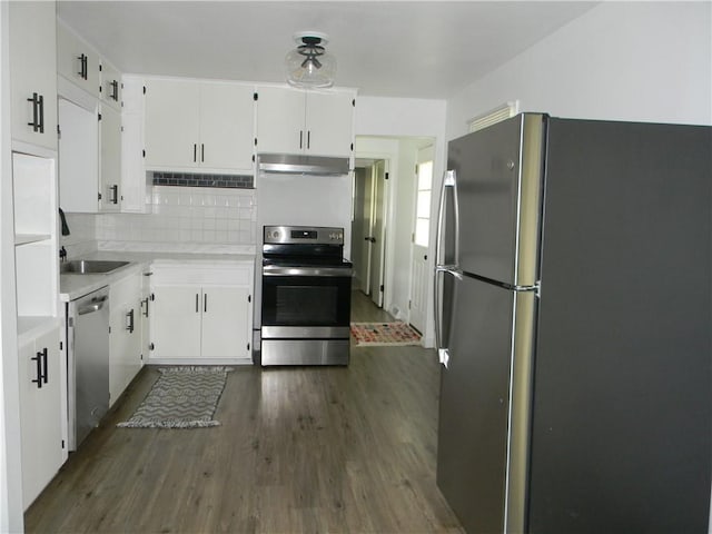 811 E Garfield St, Iola, KS 66749 - kitchen with appliances with stainless steel finishes, under cabinet range hood, dark wood-type flooring, and white cabinetry
