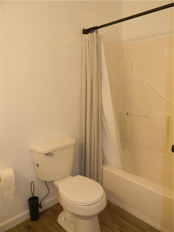 811 E Garfield St, Iola, KS 66749 - full bathroom featuring shower / tub combo with curtain and wood finished floors
