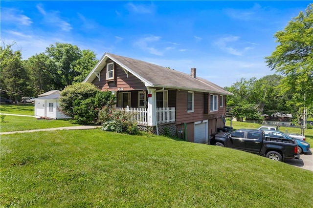 2512 S Evanston Ave, Independence, MO 64052 - view of front facade with covered porch, a garage, a chimney, and a front yard