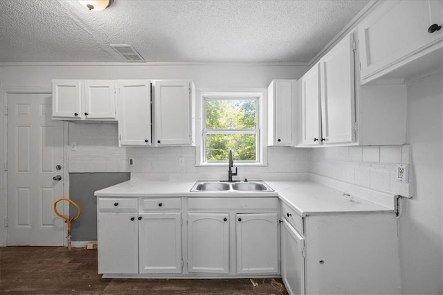 6701 Walrond Ave, Kansas City, MO 64132 - kitchen featuring a textured ceiling, backsplash, white cabinetry, dark wood-style flooring, and light countertops
