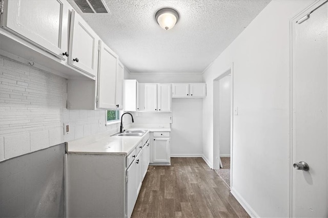 6701 Walrond Ave, Kansas City, MO 64132 - kitchen featuring dark wood-style flooring, a textured ceiling, white cabinetry, and light countertops