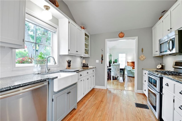 3 M St, Lake Lotawana, MO 64086 - kitchen featuring appliances with stainless steel finishes, light wood-style flooring, plenty of natural light, and tasteful backsplash