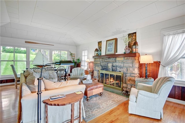 3 M St, Lake Lotawana, MO 64086 - living room featuring wood finished floors, a stone fireplace, and vaulted ceiling