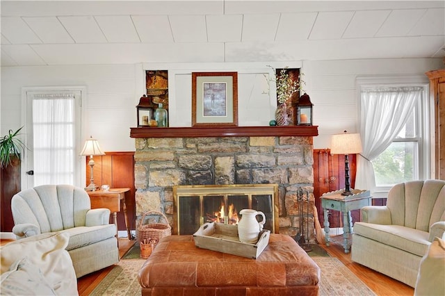 3 M St, Lake Lotawana, MO 64086 - living area with wood finished floors, a stone fireplace, and a decorative wall