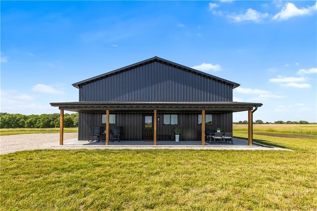 1372 N 150th Rd, Baldwin City, KS 66006 - rear view of house with a patio, board and batten siding, and a yard