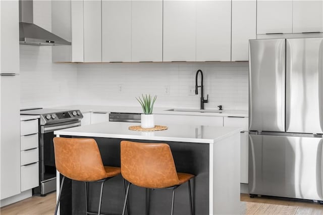 1372 N 150th Rd, Baldwin City, KS 66006 - kitchen featuring appliances with stainless steel finishes, wall chimney range hood, light countertops, a kitchen island, and backsplash