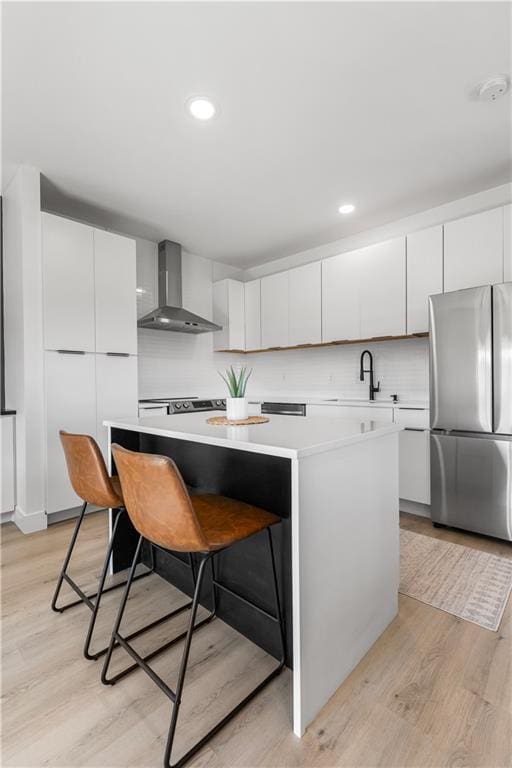 1372 N 150th Rd, Baldwin City, KS 66006 - kitchen with freestanding refrigerator, wall chimney range hood, light countertops, a breakfast bar, and a kitchen island