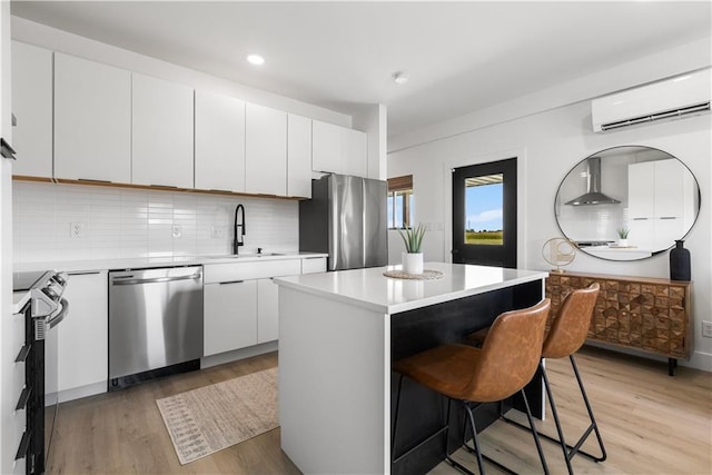 1372 N 150th Rd, Baldwin City, KS 66006 - kitchen featuring stainless steel appliances, a wall mounted AC, wall chimney exhaust hood, light countertops, and a kitchen island
