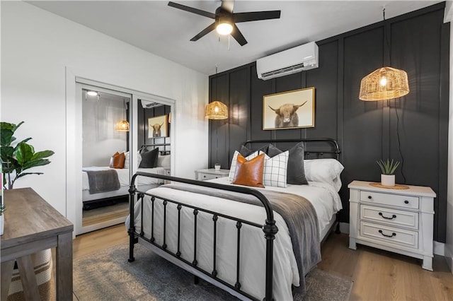 1372 N 150th Rd, Baldwin City, KS 66006 - bedroom with a wall mounted air conditioner, wood finished floors, and a ceiling fan