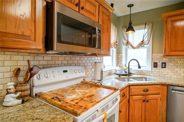 101 Shasta Daisy Dr, Smithville, MO 64089 - kitchen with stainless steel appliances, brown cabinets, backsplash, and pendant lighting